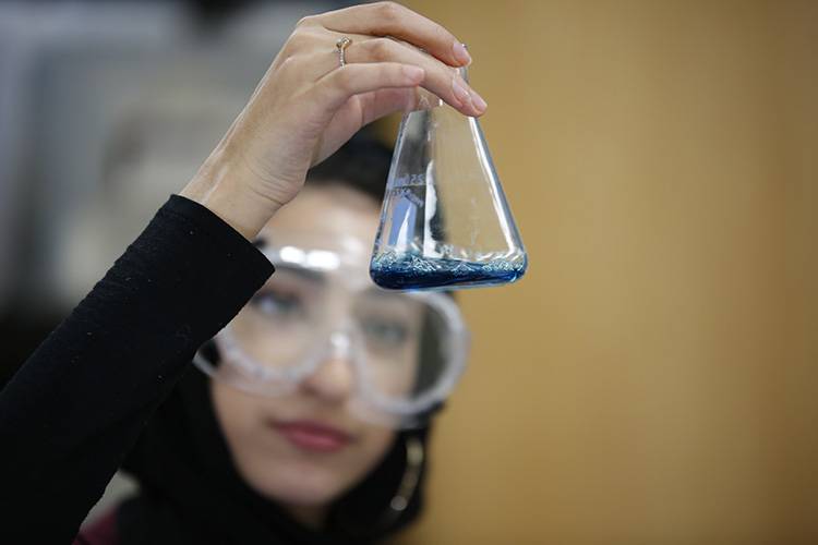 High student holding a beaker in a science lab